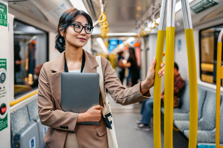 Young Asian Businesswoman Holding A Laptop While Riding In A Subway Train In Sydney In Australia